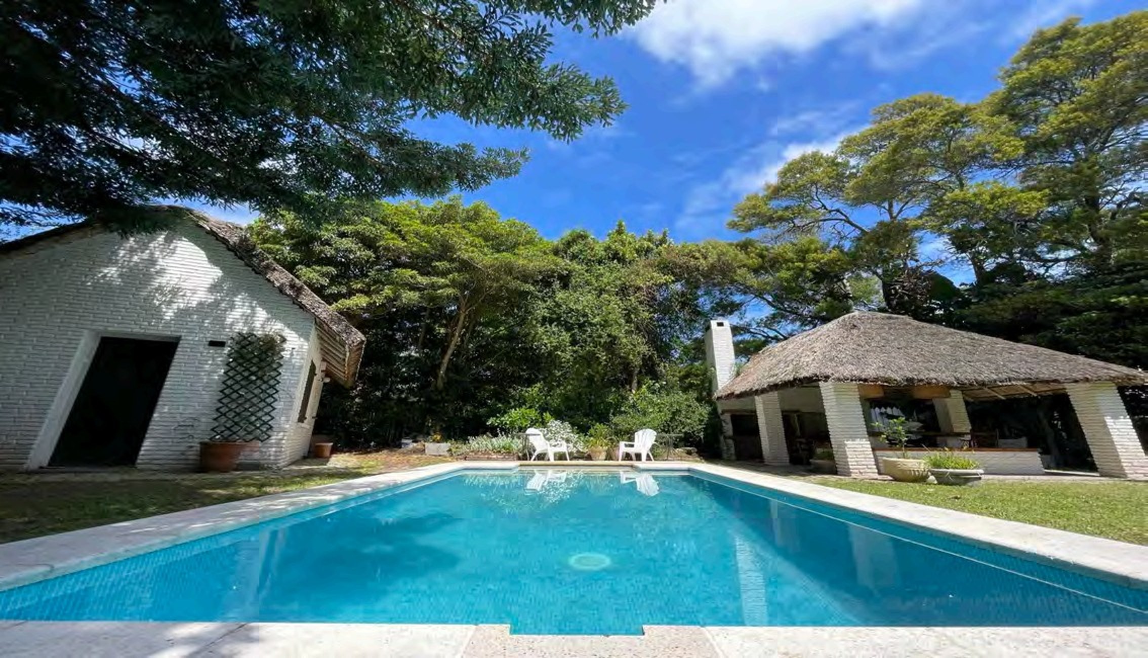 Swimming pool and thatched quincho in the garden of Chalet Nymphenburg