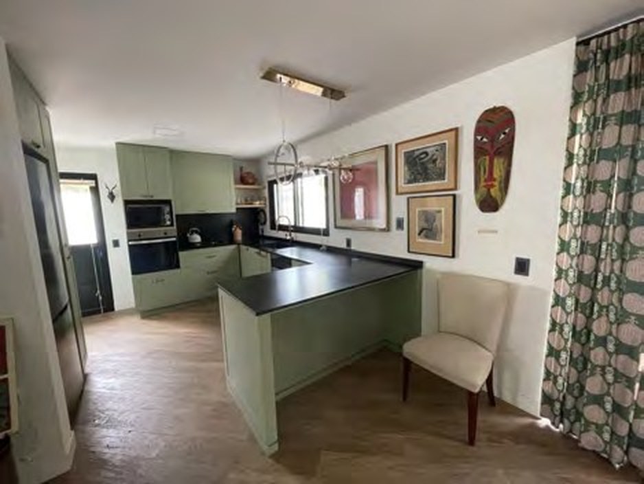 Open-plan modern kitchen with sage cabinetry and appliances