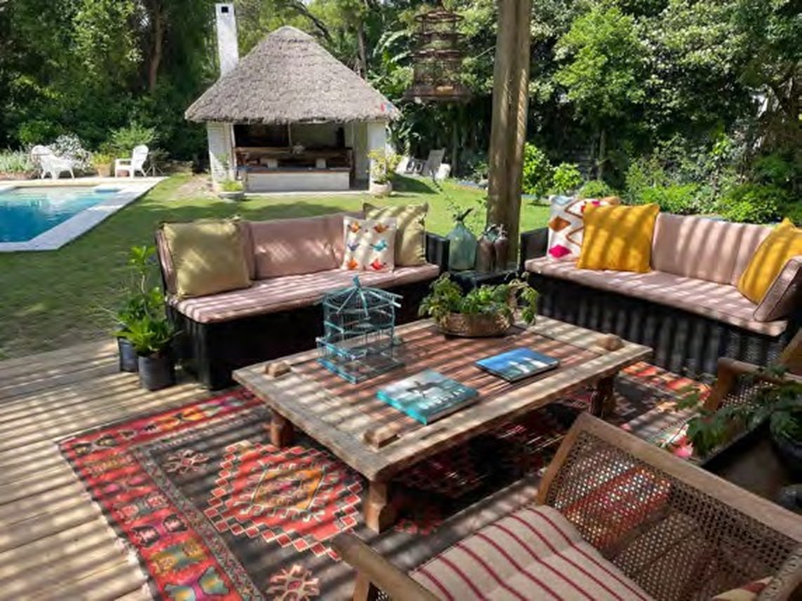 Covered terrace with sofas, kilim rugs and low table